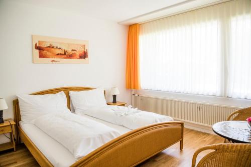 a bed sitting in a room with a window at Hotel & Bildungszentrum Matt in Schwarzenberg