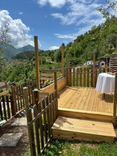 une terrasse en bois avec une table et une clôture dans l'établissement Comme à la maison, à Lantosque