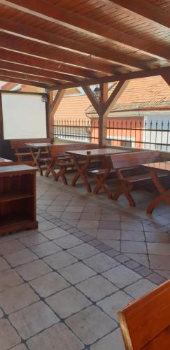 a group of wooden benches sitting under a wooden roof at MINI POOL ROOMS - ULTRACENTRAL - piscina cu hidromasaj in Oradea