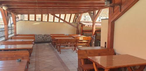 a restaurant with wooden tables and wooden benches at MINI POOL ROOMS - ULTRACENTRAL - piscina cu hidromasaj in Oradea