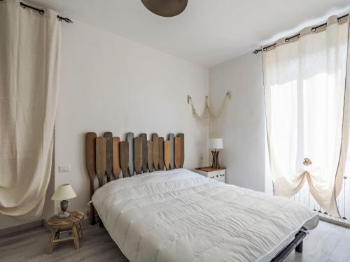 a bedroom with a large bed with a wooden headboard at Apartment Marina by Interhome in Dolcedo