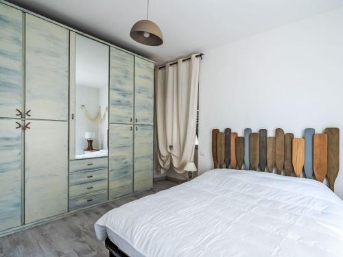 a bedroom with a large white bed and a mirror at Apartment Marina by Interhome in Dolcedo