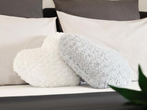 a white heart shaped pillow sitting on a bed at Apartment Cook P9-3 by Interhome in Bouveret