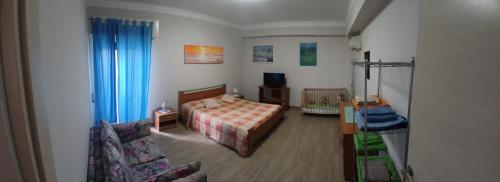 ein Schlafzimmer mit einem Bett und einem Sofa in einem Zimmer in der Unterkunft CasaLory in Catania