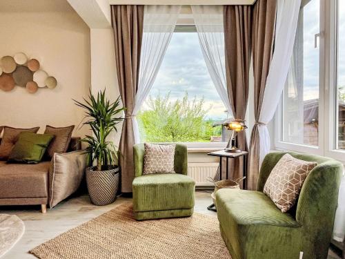 ein Wohnzimmer mit einem Sofa und Stühlen sowie einem großen Fenster in der Unterkunft Apartment Rachel by Interhome in Velden am Wörthersee