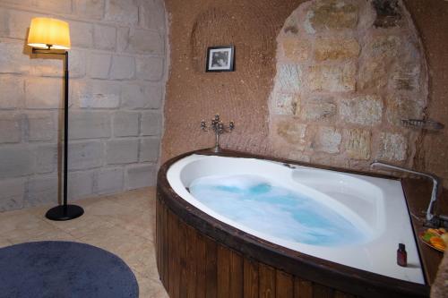 a bath tub in a room with a stone wall at Vigor Cappadocia - Special Class in Uchisar