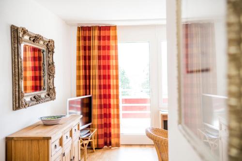 a living room with a mirror and a television at Hotel & Bildungszentrum Matt in Schwarzenberg