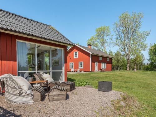 une maison rouge avec une terrasse dotée de chaises et d'un barbecue dans l'établissement Holiday Home Flugebacken - VGT101 by Interhome, à Sandhem