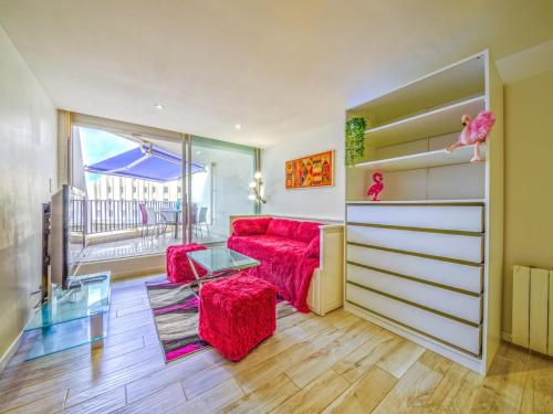 un salon avec un canapé rouge et une table dans l'établissement Apartment Le Parador-4 by Interhome, à La Grande Motte