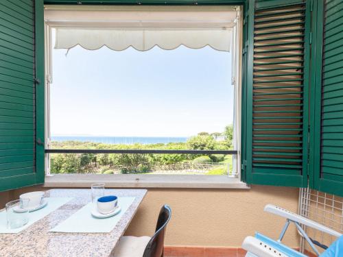 a table and chairs in a room with a window at Apartment Il Veliero by Interhome in Punta Ala