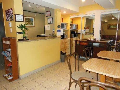 a restaurant with tables and a counter and a kitchen at Hotel de l'Elysée in Montreal