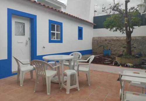 a patio with a table and chairs and a tree at Casa do Cabeço - Termas da Sulfúrea in Cabeço de Vide
