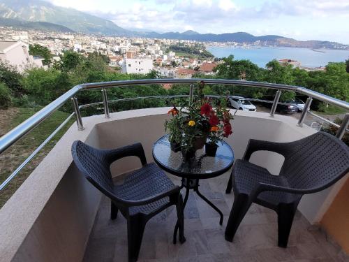 a table with two chairs and a vase of flowers on a balcony at Montenegro Apartments Phoenix With Pool in Bar