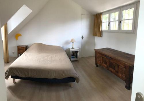 une chambre avec un lit, une commode et une fenêtre dans l'établissement Land & Sea Bretagne, à Trégunc