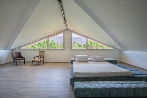 een grote kamer met een bed en twee stoelen bij Luxury Marble House in Pietrasanta