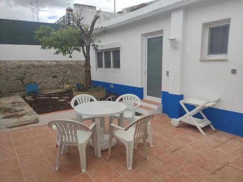 a patio with a table and chairs and a tree at Casa do Cabeço - Termas da Sulfúrea in Cabeço de Vide