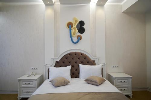 a bedroom with a bed with two pillows and a mask at Igit Plaza Hotel in Gyumri