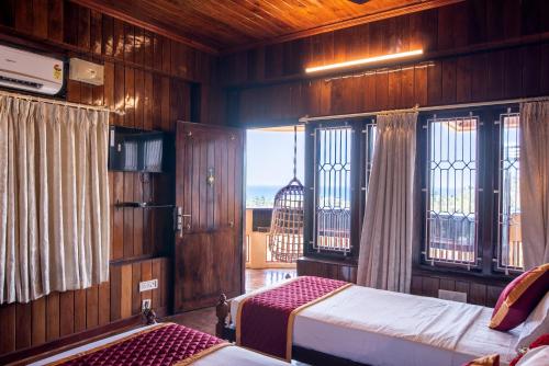 可瓦蘭的住宿－ATREYA AYURVEDA BEACH RETREAT，卧室设有木墙、窗户和1张床。