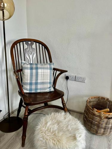 a rocking chair with a pillow and a white rug at Beautiful newly renovated farmhouse in Gortatlea