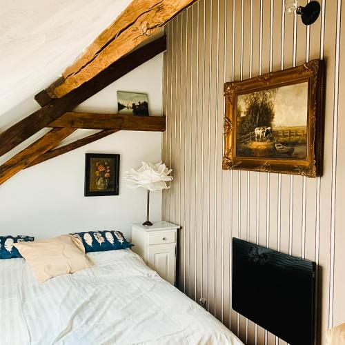 une chambre avec un lit et un tableau au mur dans l'établissement Silent Valley Bed & Breakfast, à Larochemillay