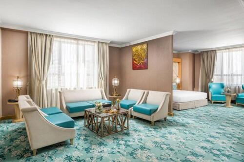 Elaf Al Taqwa Hotel في المدينة المنورة: غرفة معيشة مع كنب وكراسي في غرفة الفندق