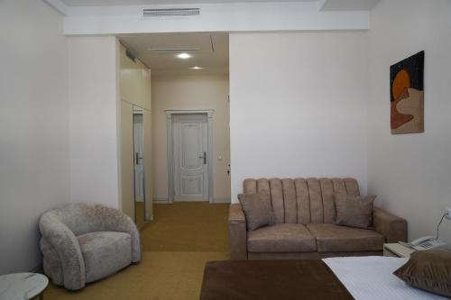 a living room with a couch and a chair at Igit Plaza Hotel in Gyumri