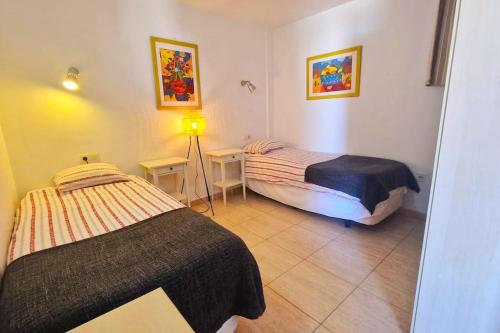a bedroom with two beds and a lamp in it at Comfortable 2 bed in Arguineguín in Arguineguín