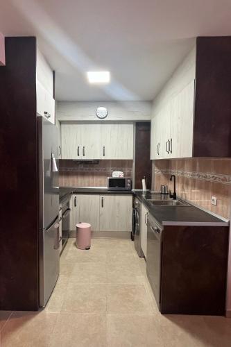 a kitchen with white cabinets and a black counter top at Apartamento Pilarín in Alcañiz
