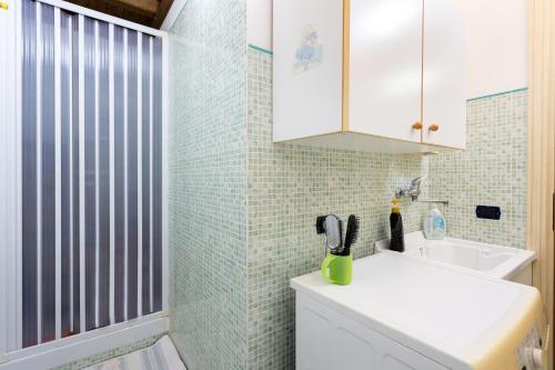 une salle de bain avec un lavabo blanc et une douche dans l'établissement La casa di Giusy, à Mazara del Vallo