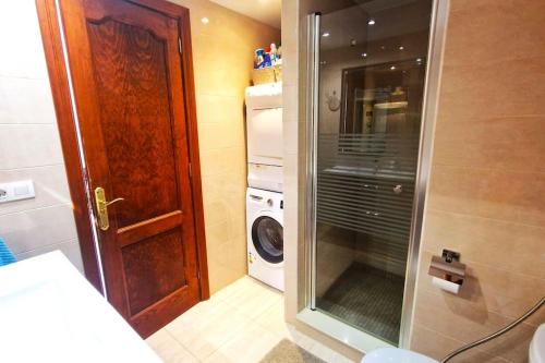 a small bathroom with a washing machine and a door at Comfortable 2 bed in Arguineguín in Arguineguín