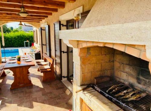 an outdoor patio with a stone fireplace and a table at Villa Seaside in Krk