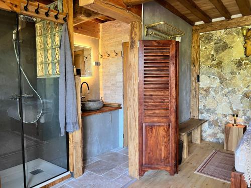 une salle de bain avec douche et porte vitrée dans l'établissement Les Magnels, à Valleraugue