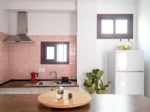 a kitchen with a wooden table and a white refrigerator at Casa Nueva in Jimena de la Frontera