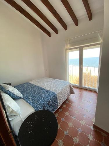 - une chambre avec un lit et une grande fenêtre dans l'établissement Casa en la Isla de Tabarca, à Tabarca