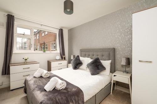 a bedroom with a bed with towels on it at K Suites - Station Road in Hinckley