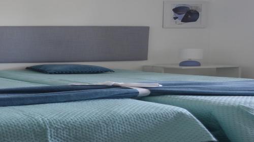two beds with blue blankets on top of them at HM - HouseMirage in Paço de Arcos