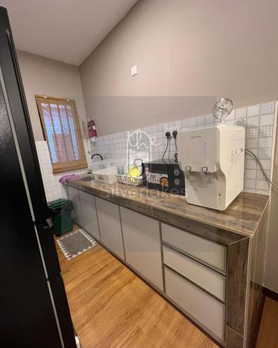 a kitchen with a counter with a sewing machine on it at The9 Silverlakes Homestay in Batu Gajah