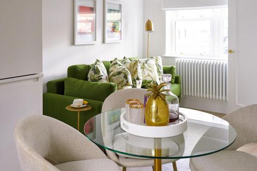 a living room with a green couch and a glass table at The Nici in Bournemouth