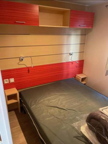 - une chambre avec un lit et deux lumières sur le mur dans l'établissement Mobil home 6 personnes sur camping, à La Boissière-de-Montaigu
