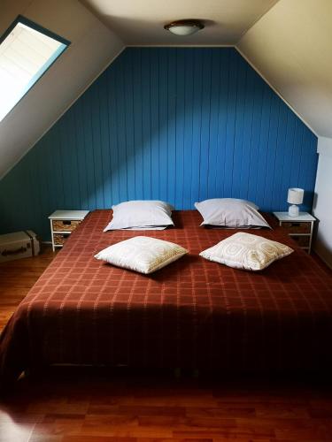 une chambre avec un grand lit avec deux oreillers dessus dans l'établissement GITE BRETON sur la côte de granit rose, à Pleudaniel
