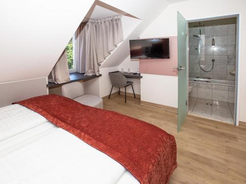 ein Schlafzimmer mit einem Bett und ein Badezimmer mit einer Dusche in der Unterkunft Hotel Bargenturm in Lüneburg