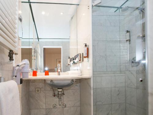 ein Bad mit einem Waschbecken und einer Dusche in der Unterkunft Hotel Bargenturm in Lüneburg