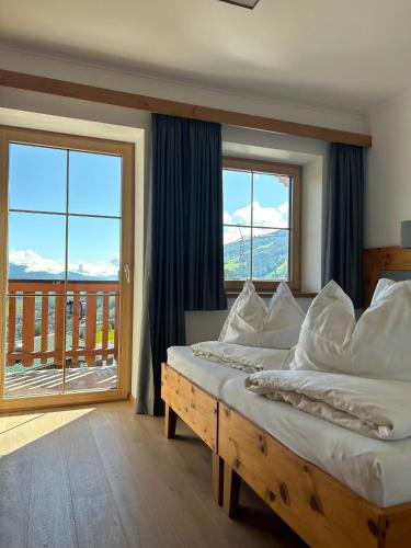 a bedroom with two beds and a large window at La Montana Ski & Hiking LODGE in Schladming