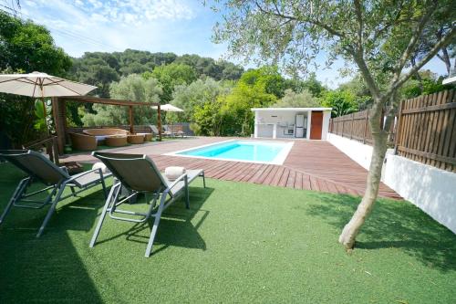 une cour avec deux chaises et une piscine dans l'établissement Villa luxe californienne - Piscine Poolhouse, à Antibes