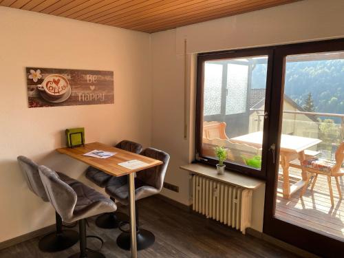 a room with a table and chairs and a balcony at Ferienwohnung-Bali in Bad Liebenzell