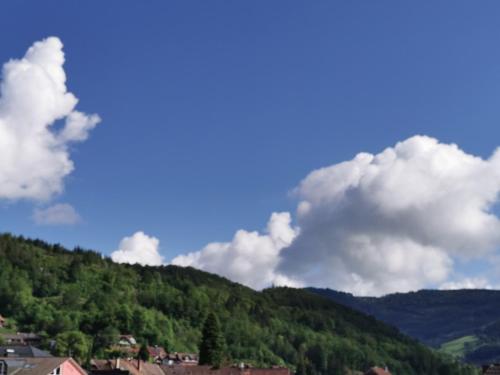Eine Stadt auf einem Berg mit Wolken in der Unterkunft Ferienwohnung Sternenblick in Schönau im Schwarzwald