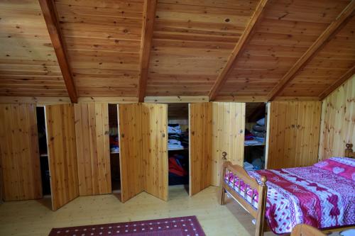 a bedroom with wooden walls and a bed in a room at Velipoja Private Chalet in Velipojë