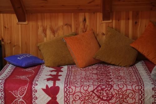 a bed with colorful pillows on top of it at Velipoja Private Chalet in Velipojë