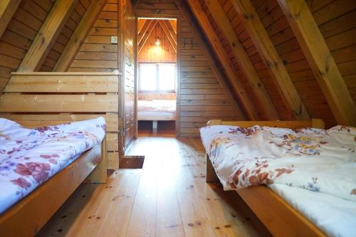 Habitación con 2 camas en una cabaña de madera en The Rainbow - Domki Letniskowe, en Dźwirzyno