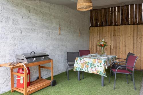 a table and chairs and a grill in a room at Gite de la Bouliniere in Challans